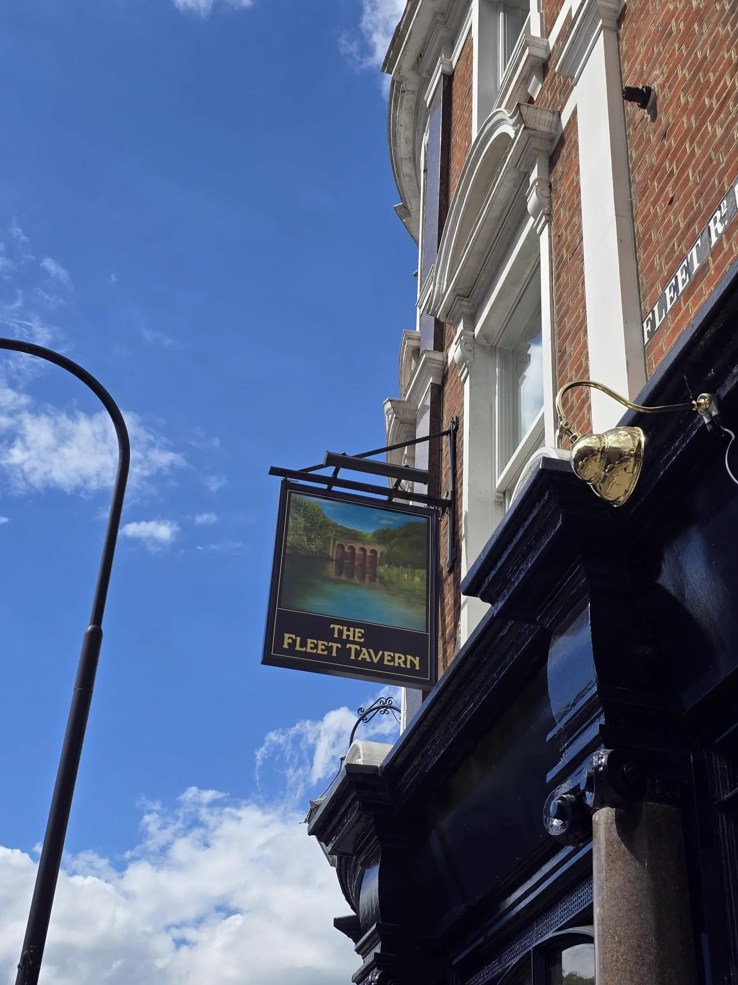 The Fleet Tavern exterior pub sign on Fleet Road against a blue sky